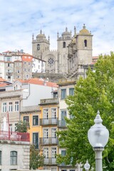 Aerial view of traditional houses in the old town of Porto with the Cathedral in the background. Houses with colorful terraces and full of windows. Small and cozy building. Porto, Portugal. - 788985817