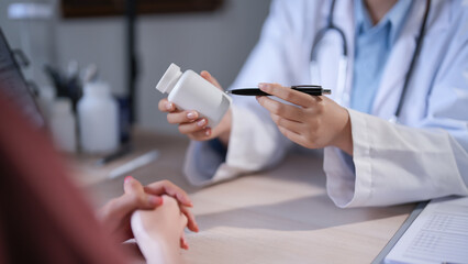 Asian psychologist women pointing on pills bottle to explaining medicine and prescription to female patient while giving counseling about medical and mental health therapy to female patient in clinic - 788990883