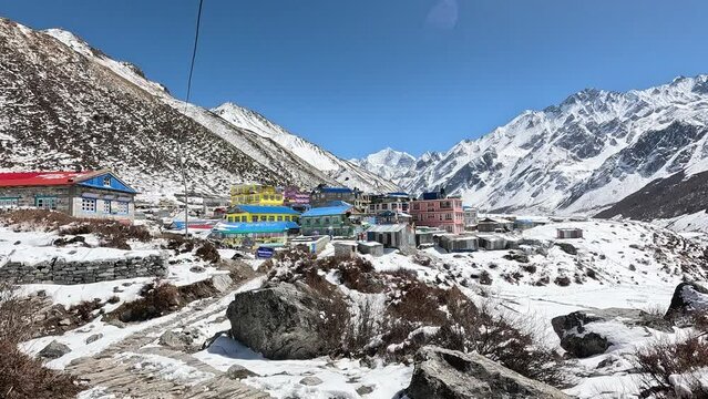 Approaching colourful houses and icy valley of Kyanjin Gompa. Langtang valley trek, Himalayas, Nepal