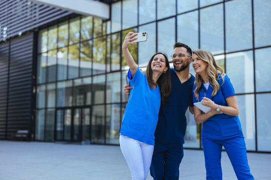 Cheerful medical students taking selfie and having fun at the university. Close up of Diverse medicine students in uniform taking selfie in front of Hospital. To remember our medical internship