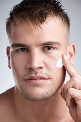 Skincare, lotion and portrait of man in studio with moisturizer for dermatology, wellness or...
