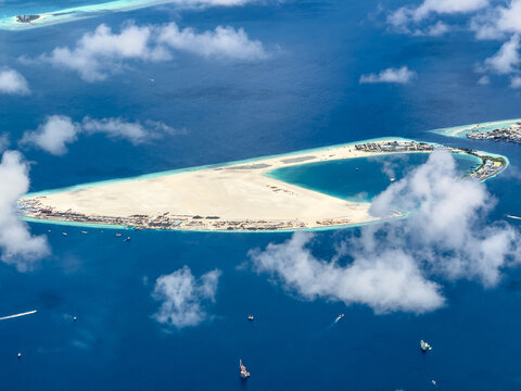 aerial landscape view of the Gulhi Falhu Island in Maldives with huge sand beach, buildings and infrastructure, partly covered with with clouds