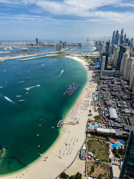 aerial city view of Dubai along JBR Beach, Marina Beach with many  famous buildings along the coastline of Dubai, and Skydive Dubai Airport, people sunbathe on the beach