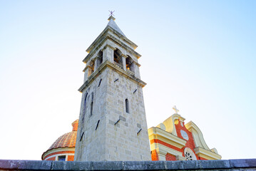 The bell tower of the Church of St. Matthew in the Montenegrin town of Dobrota - view from bottom to top - obrazy, fototapety, plakaty