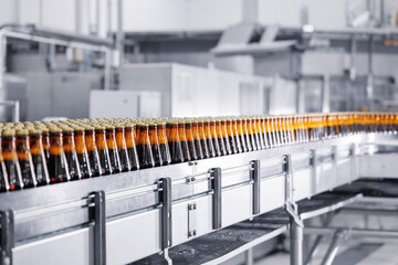 Automated modern beer bottling factory line with rows of filled bottles