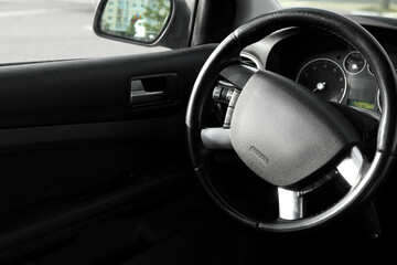 Black steering wheel and dashboard in car