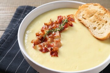Tasty potato soup with bacon and crouton in bowl on table, closeup