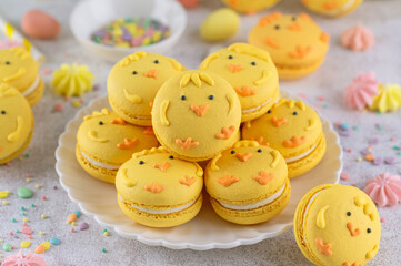 Cute Easter chick macarons. French macarons with vanilla cream and lemon curd on a concrete...