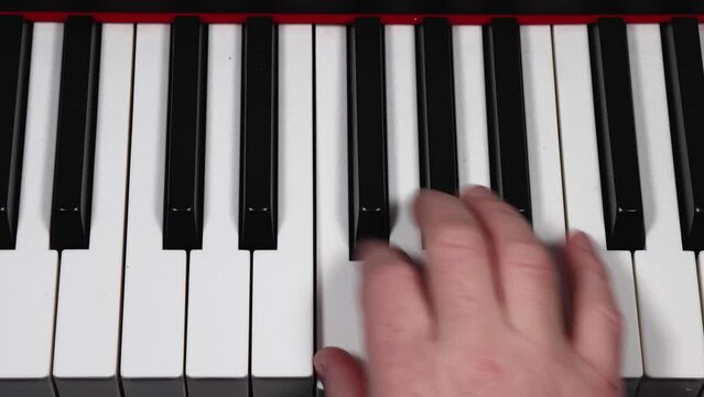 Footage of a males caucasian man showing his hand playing the piano