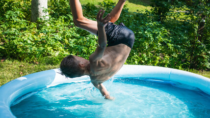 Little boy jumps into the pool in the yard