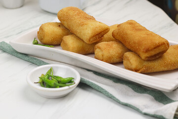 Risoles, one of Indonesian popular snack. Made from crepe skin filled with vegetables, chicken, coated with bread crumbs and deep fry. White marble background.   