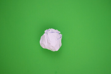 White crumpled paper on a green background. Recycling concept.