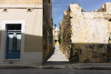 Gozo island narrow street. European architecture. Blue wood door. Urban sunlight. Malta holiday...