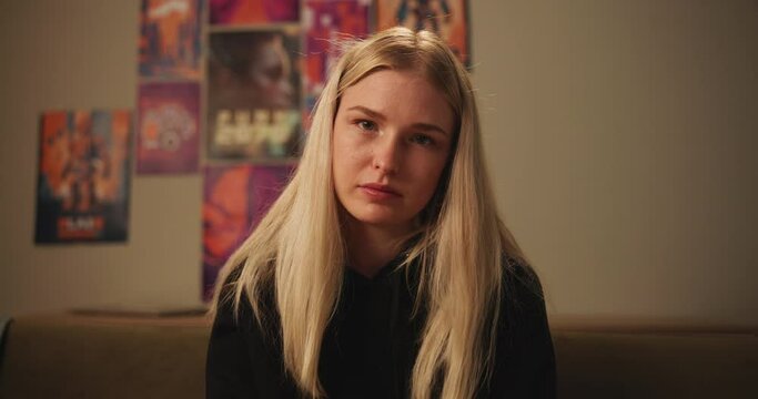 Mental health, face and woman with depression, sad and unhappy on sofa in living room, house and home. Anxiety, emotional and gen z girl with stress, problem and miserable female person on couch