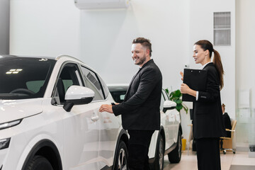 An interested buyer consults with a car dealership manager about the models and characteristics of...
