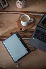 Wooden table with laptop and notepad for notes
