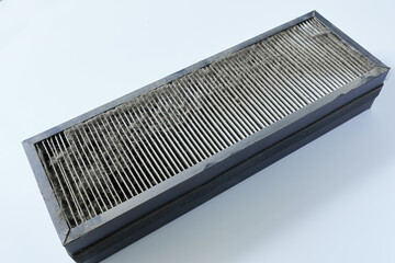 An old air filter for an air conditioner on a white background, closeup.