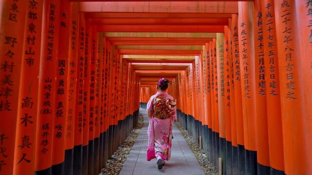 Slow motion video, Asian woman in traditional Japanese kimono at Fushimi Inari Shrine in Kyoto Japan