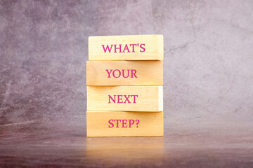 What is your next step symbol written on wooden blocks on a dark background
