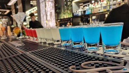 Blue Lagoon, White cosmopolitan and Pink Lady cocktail shots are placed in series for a group of...