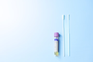 A flu test and a swab are on a blue background