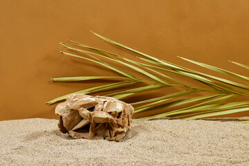 Summer sand with abstract stone podium and palm leaf 