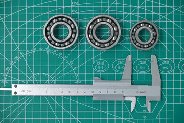 Measure caliper and roller bearings on cutting mat