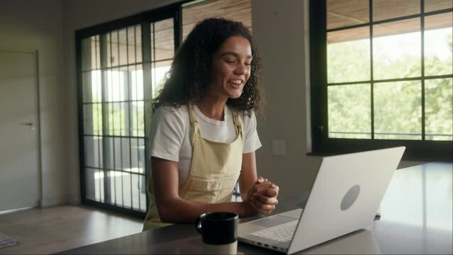 A woman seated at a table using a laptop computer by the window