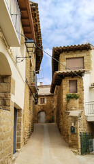 A narrow alleyway with rustic houses on either side