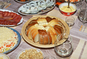 Sliced bread in wicker plate on table with appetizers.