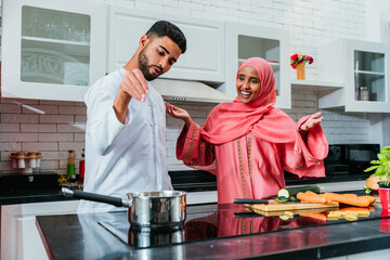 Happy middle eastern couple wearing traditional arab clothing at home