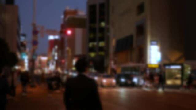 out of focusing blurred local street road view in Hakata Fukuoka city area with some traffic and people pedestrian in sunset time