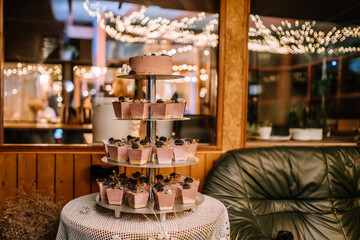 Valmiera, Latvia- July 28, 2023 - A tiered dessert stand with cakes and mousses in a warmly lit...