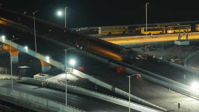 Construction Of New Highway Is Underway In Night Time. Workers Install Road Barriers. Men At Work. Construction Of New Road Roundabout Time Lapse, Timelapse, Time-lapse. Preparing Road For New Asphalt