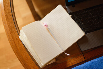 blank open striped notebook with a pen inside on the desk