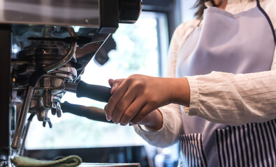 Barista making fresh espresso coffee from machine in coffee shop