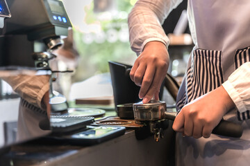 Close up barista using manual hand grinding making fresh espresso coffee in coffee shop