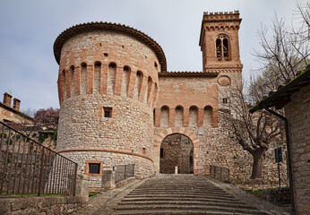 Corciano, Perugia, Umbria, Italy: the city gate Porta di Santa Maria with the round tower and the bell tower of the church - 789109069