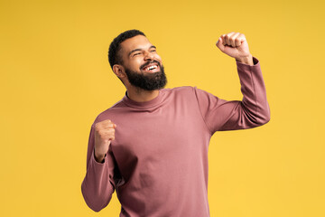 Young African American moving dancing while celebrating, posing in studio, over yellow background