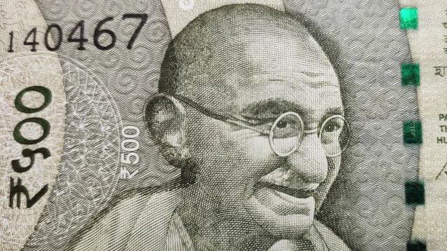 Freedom fighter and father of the india nation mohandas karamchand gandhi, bapu or mahatma gandhi face on different colorful indian rupee currency notes. Extreme closeup macro top view