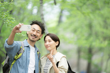 Fototapeta premium 避暑地などに旅行する中年(ミドル)のカップル スマホの自撮りで撮影する