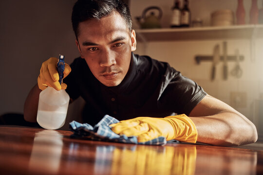 Apartment, cleaning and man with disinfectant for kitchen counter, housekeeping and bacteria. Person, home and guy with spray bottle, cloth and routine with germaphobe, remove dust and chore with ocd