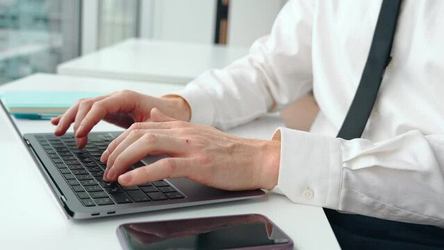 Close up view of busy professional business man manager executive, businessman entrepreneur wearing shirt and tie using laptop at work, male hands typing on computer working at office.
