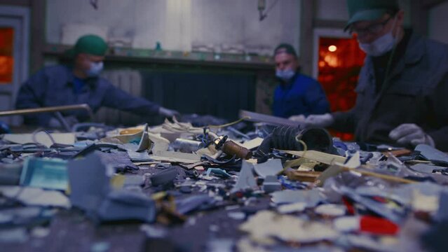 Man sorts garbage, electronics or plastic. Taking care of the environment. Waste recycling plant or garbage factory. Conveyor belt, trash moving along the line. Male have a eco-friendly work