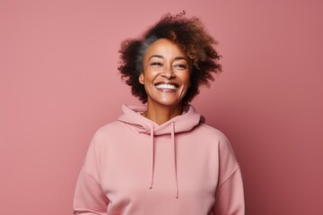Fototapeta na wymiar Portrait of a grinning afro-american woman in her 60s wearing a thermal fleece pullover over solid color backdrop