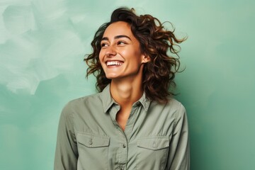 Portrait of a grinning woman in her 30s sporting a breathable hiking shirt on solid pastel color wall