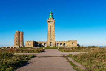Obraz premium Sous un ciel azuré, le phare du cap Fréhel, fier gardien des mers, domine les côtes d'Armor.,