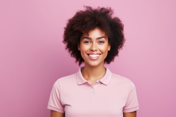 Portrait of a blissful afro-american woman in her 20s wearing a sporty polo shirt over solid pastel...