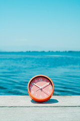 pink clock on a pier on a summer day - 789130817