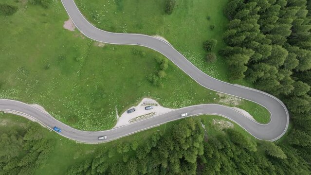 Aerial view of vehicles driving on the winding roads near Selva pass Dolomites Mountains, Trentino, South Tyrol, Italy. LuPa Creative.